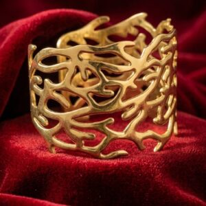 Gold-tone snake statement bangle with green accents